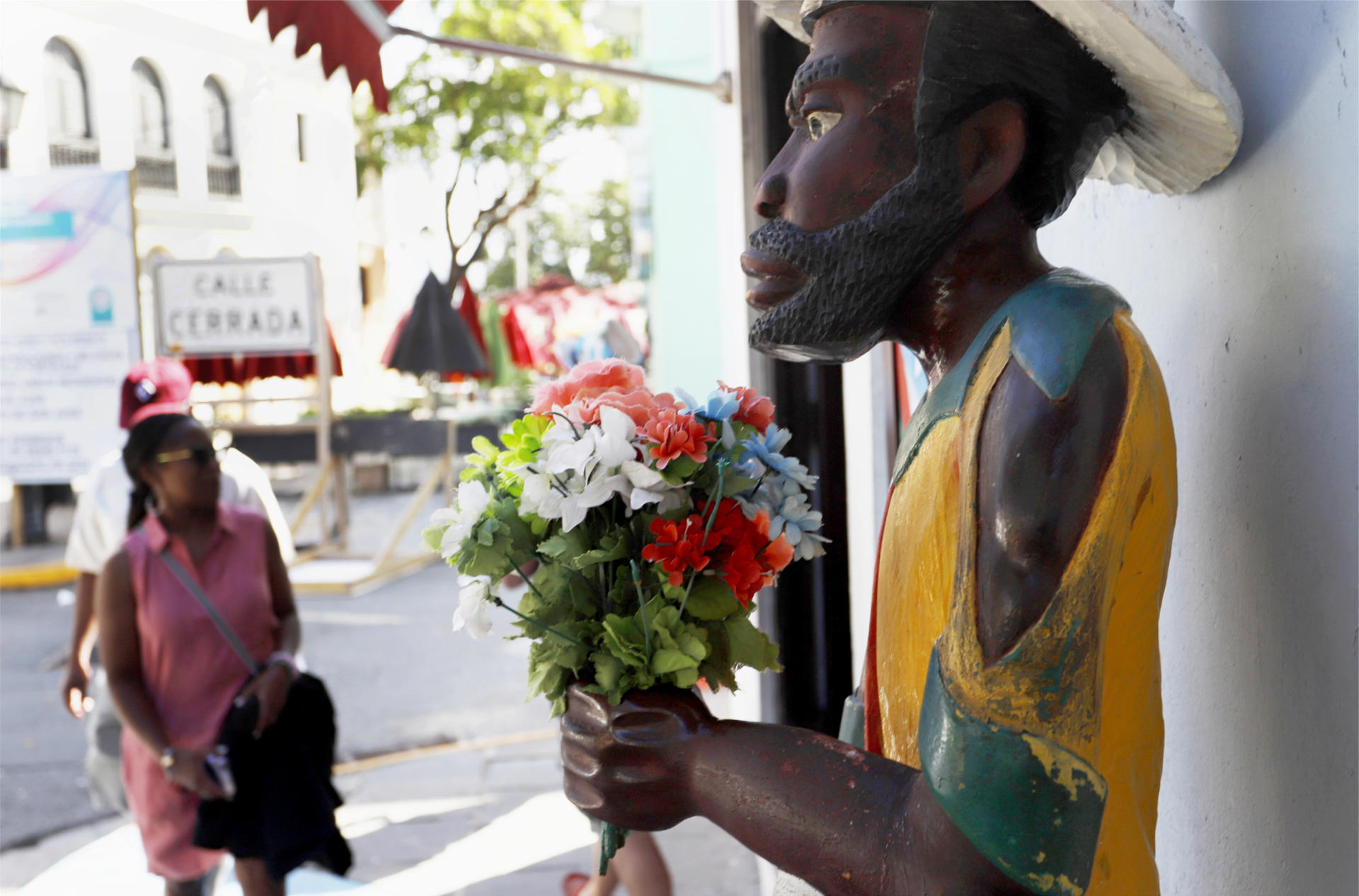 Fotografía del lunes 23 de enero donde aparece una mujer mientras camina frente a un negocio haitiano en San Juan, Puerto Rico. EFE/Thais Llorca
