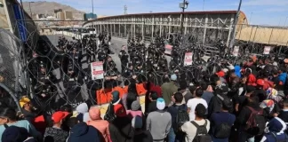 Miles de migrantes llegan a línea divisoria México-EEUU para exigir entrada