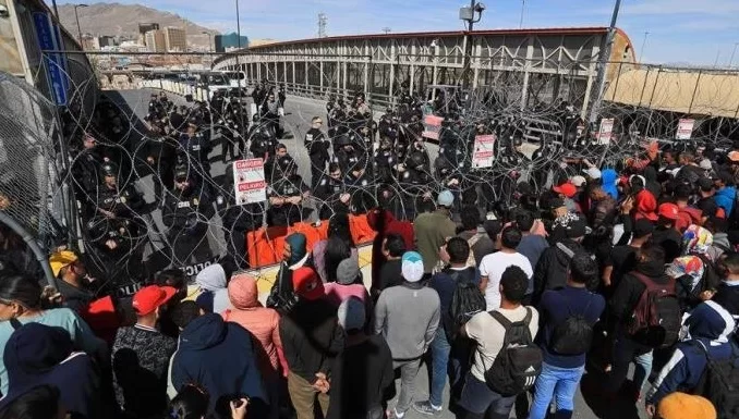 Miles de migrantes llegan a línea divisoria México-EEUU para exigir entrada