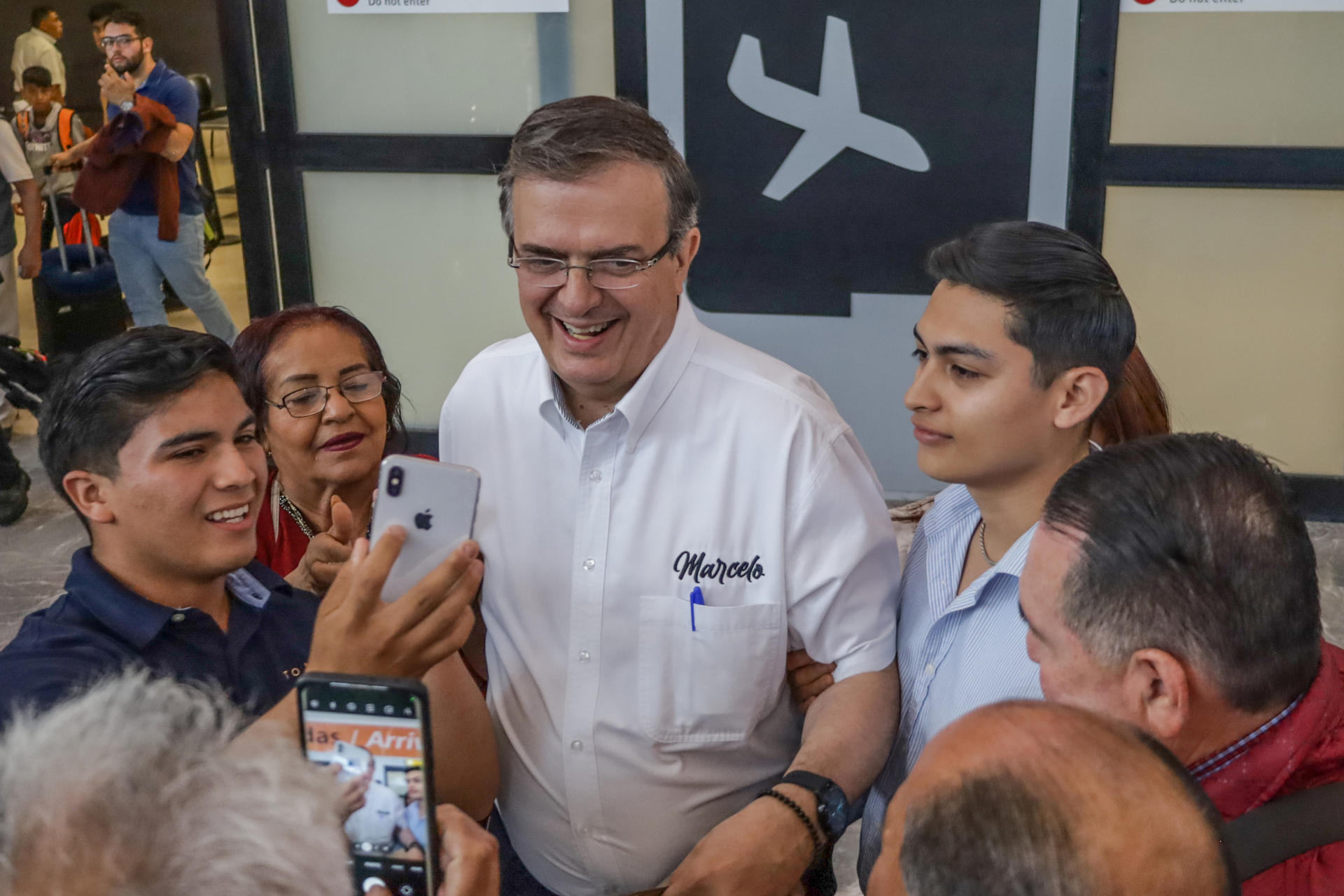 El excanciller Marcelo Ebrard, precandidato presidencial por el partido Movimiento Regeneración Nacional (Morena), saluda hoy simpatizantes a su llegada al aeropuerto de Tijuana (México). EFE/Joebeth Terríquez
