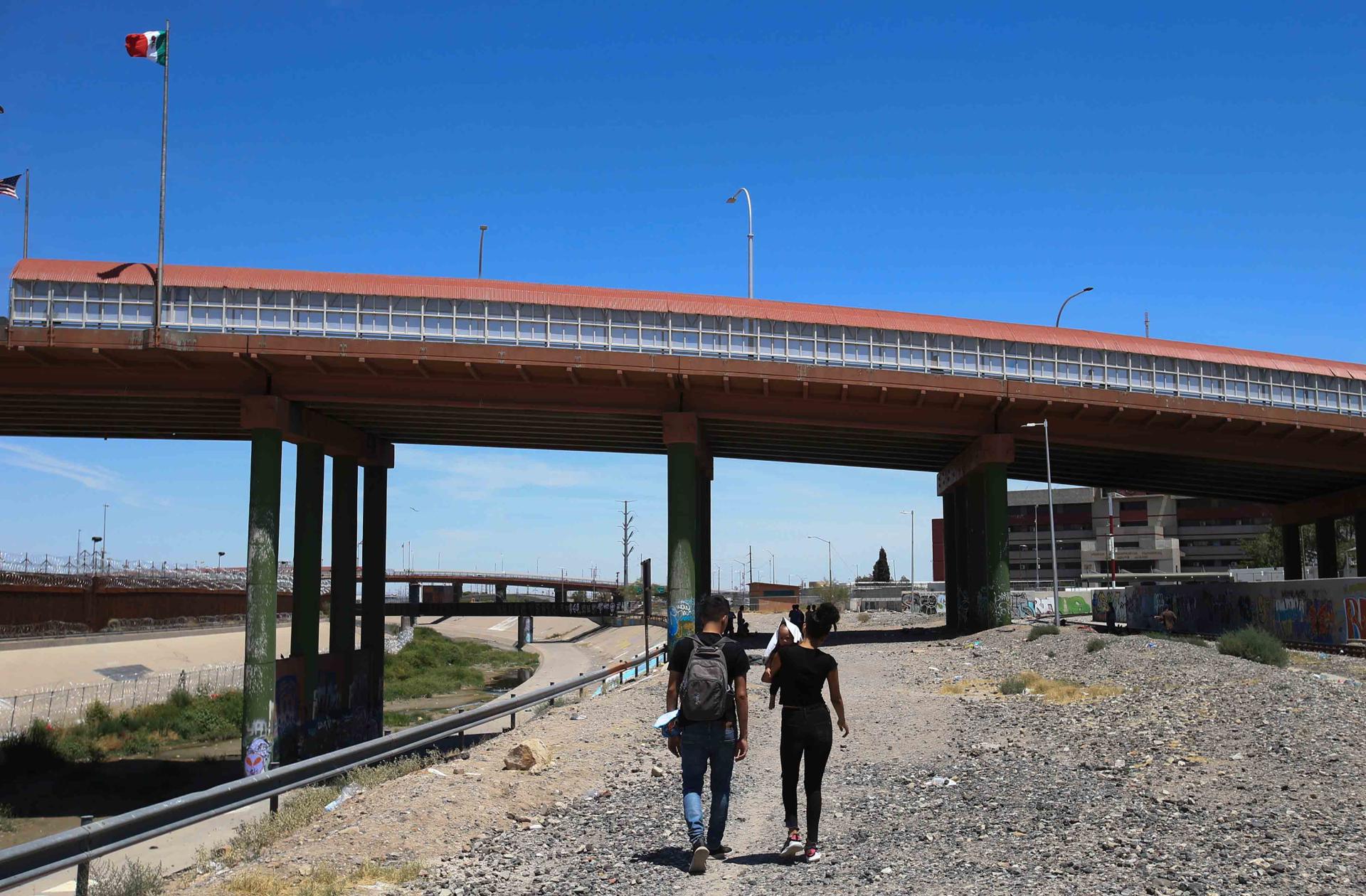 Los migrantes venezolanos Estefania Briceño y Jhondeiby Pérez caminan en las cercanías del puente Internacional Paso del Norte, el 23 de julio de 2023, en Ciudad Juárez (México). EFE/Luis Torres
