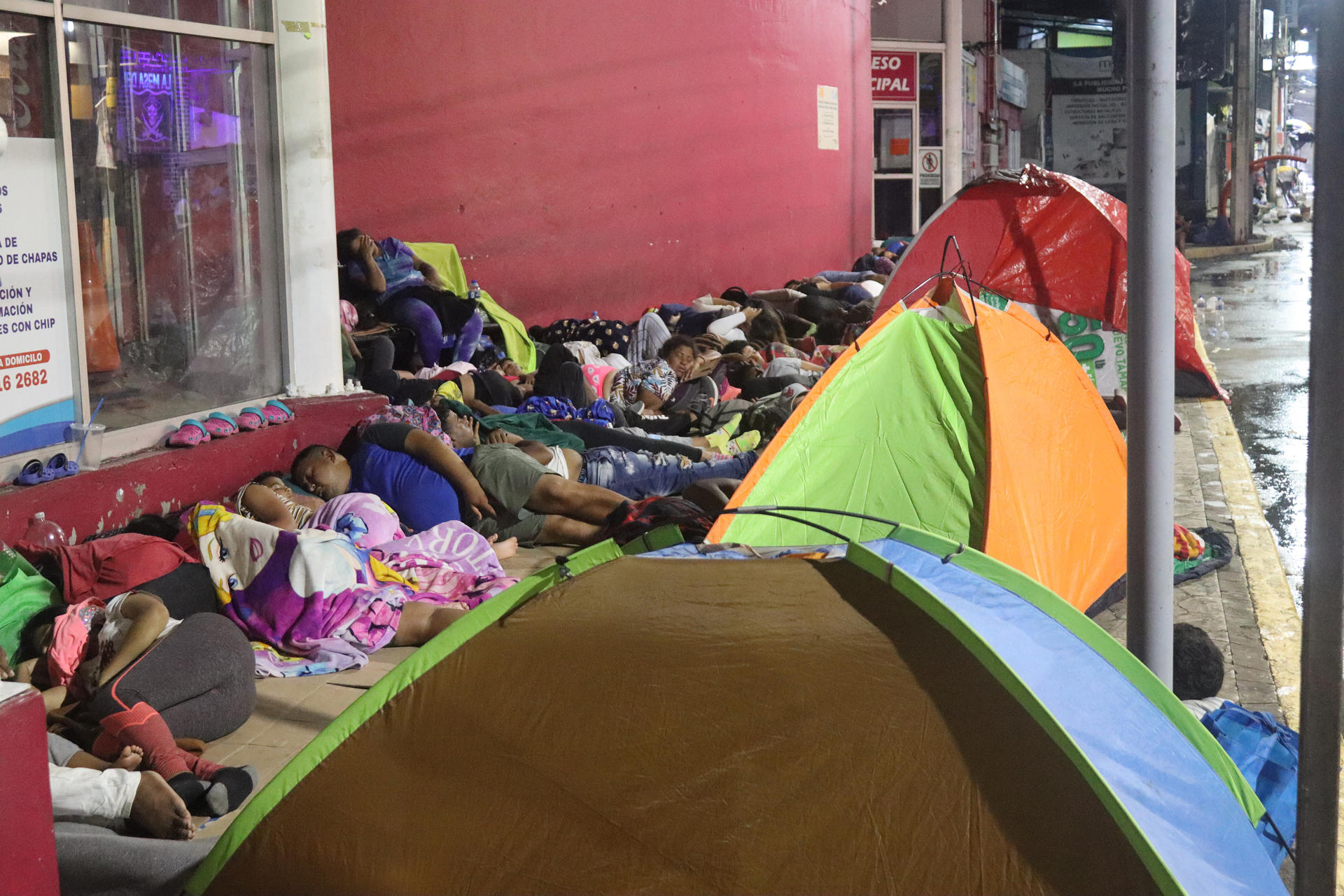 Migrantes duermen en el piso cerca al Servicio de Administración Tributaria (SAT), a esperas de tramitar su registro fiscal, en Tapachula (México). EFE/Juan Manuel Blanco
