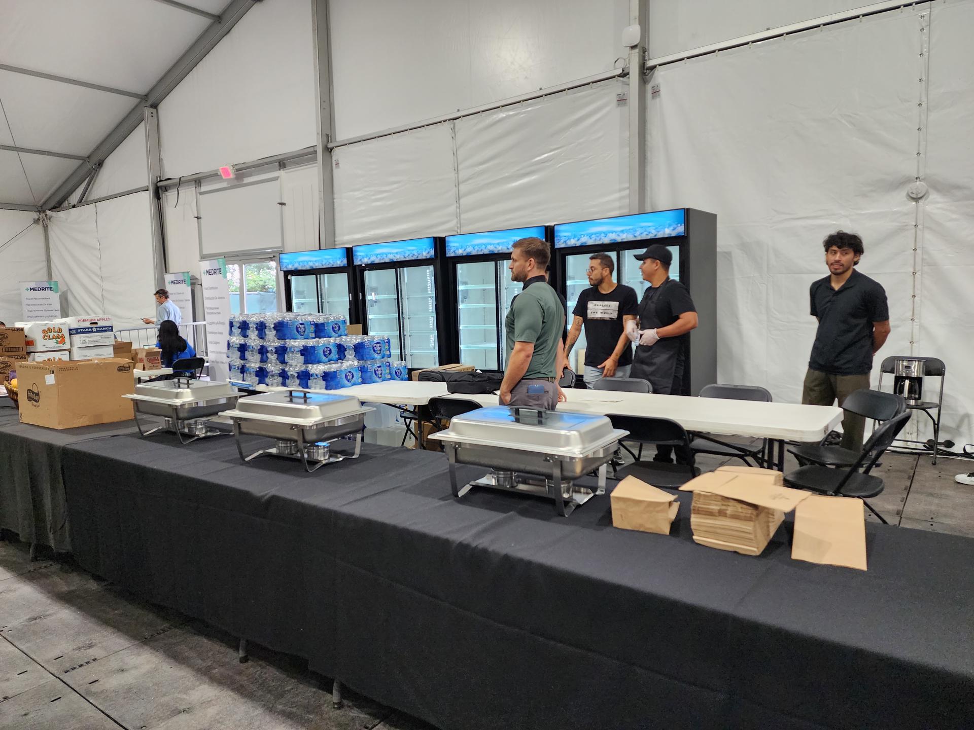 Personas reparten hoy alimentos para migrantes en el nuevo alojamiento gigante de Creedmoor, en el barrio de Queens, Nueva York (EE.UU). EFE/ Ruth E. Hernández
