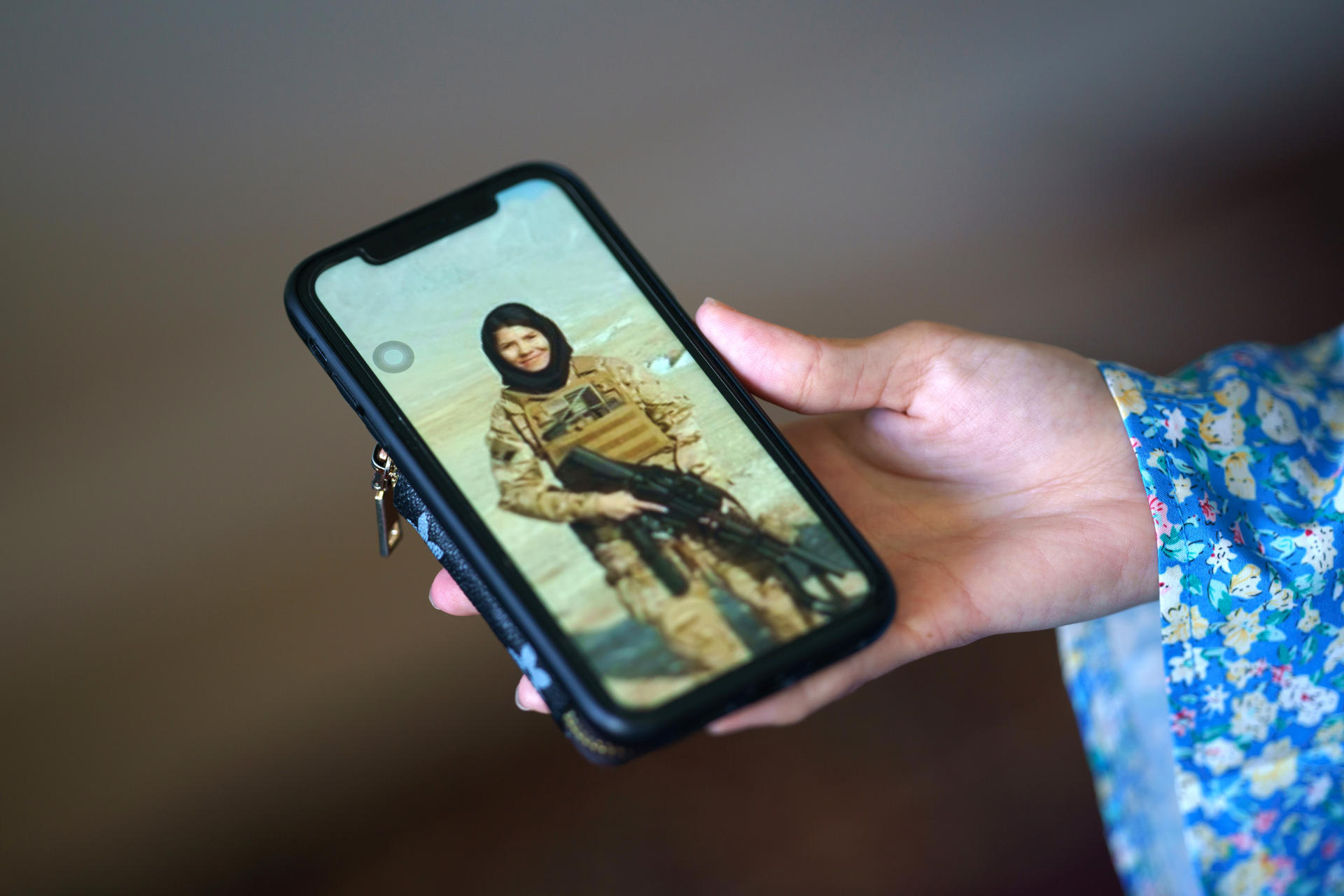 Mahnaz Akbari, ex líder del Pelotón Táctico Femenino de Afganistán muestra un teléfono móvil con una foto suya con uniforme militar, durante una entrevista el 23 de agosto de 2023 en su apartamento en las afueras de Washington DC (EE.UU.). EFE/Will Oliver

