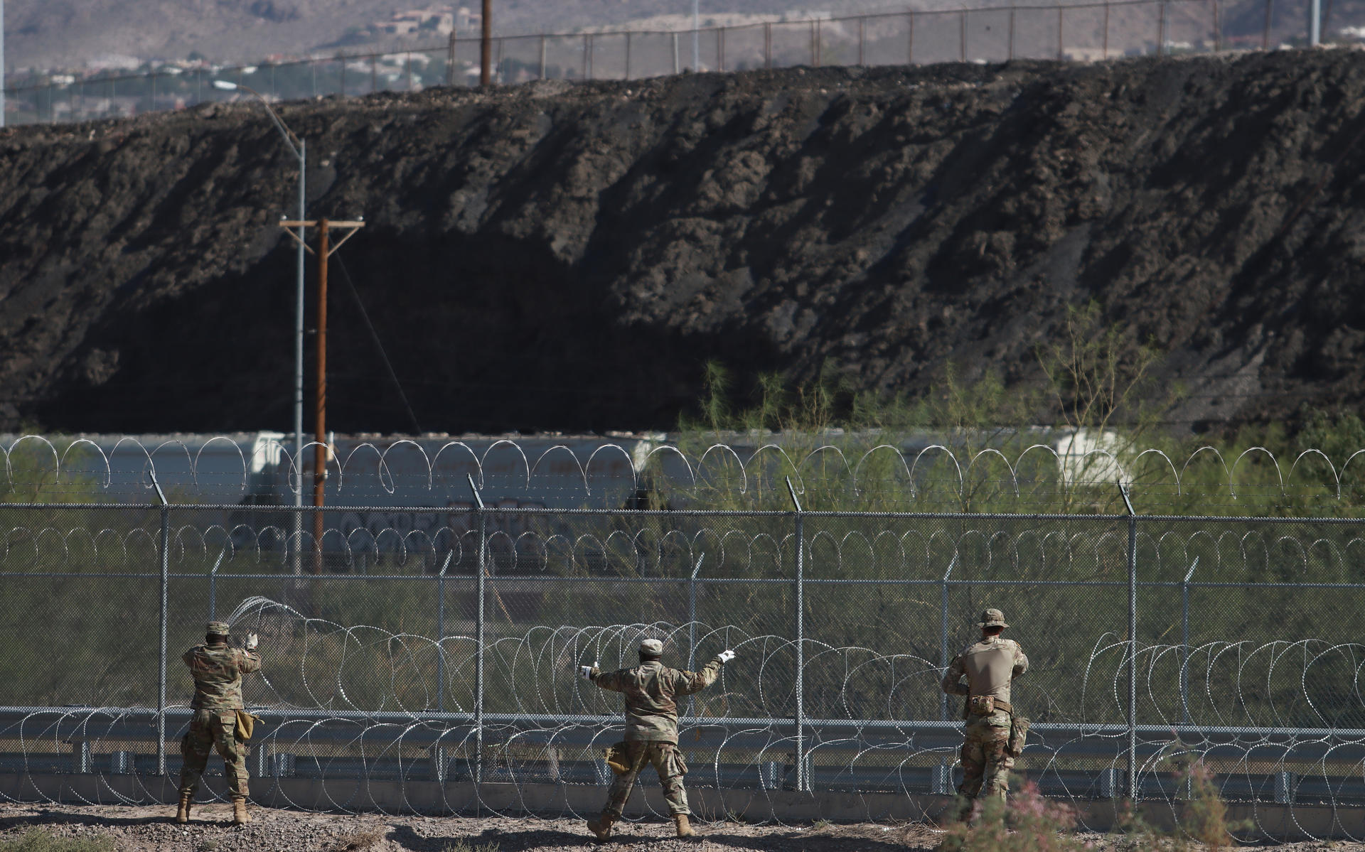 Miembros de la Guardia Nacional de Texas instalan barricadas de alambre de navajas, hoy, en el muro fronterizo en Ciudad Juárez, en Chihuahua (México). EFE/Luis Torres
