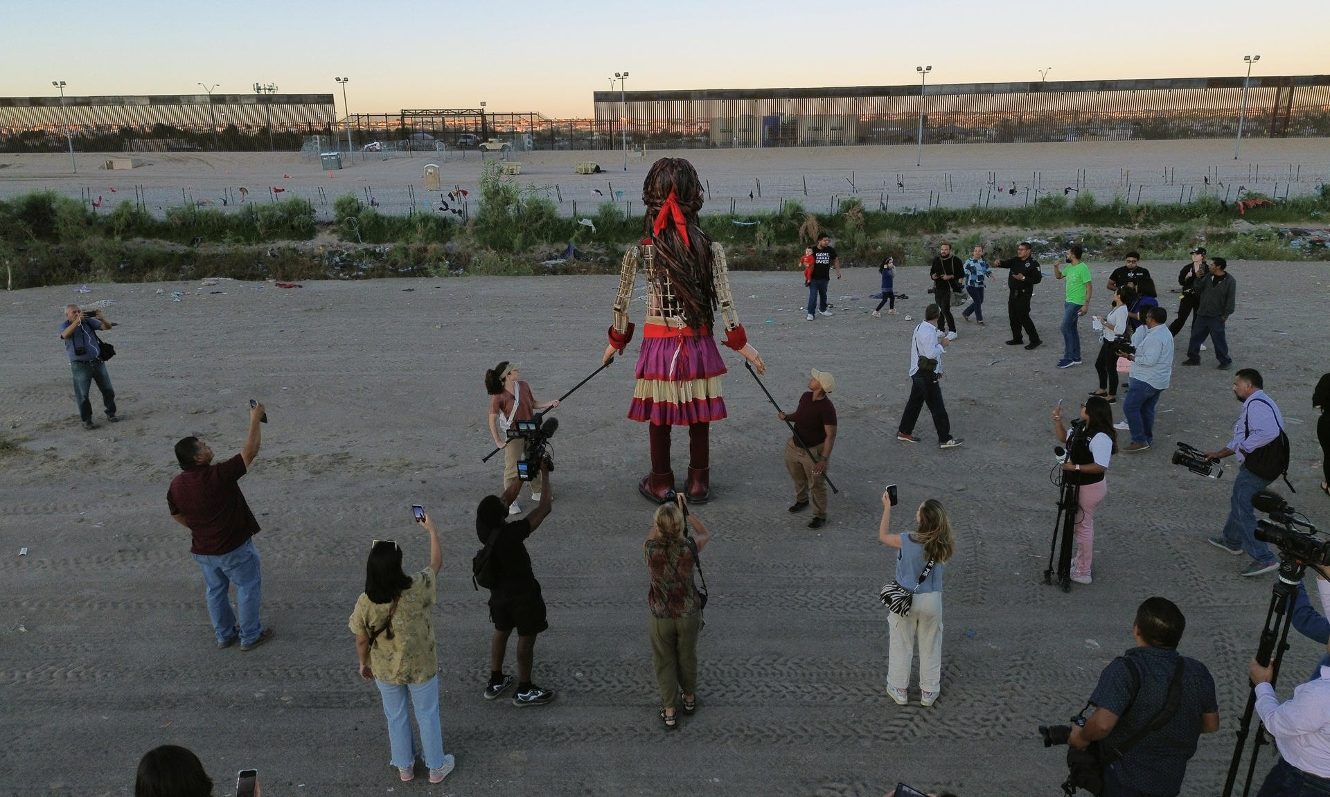 Personas observan el paso de "La Pequeña Amal", que representa a una niña siria durante un recorrido, el 26 de octubre de 2023, en Ciudad Juárez Chihuahua (México). EFE/Luis Torres.
