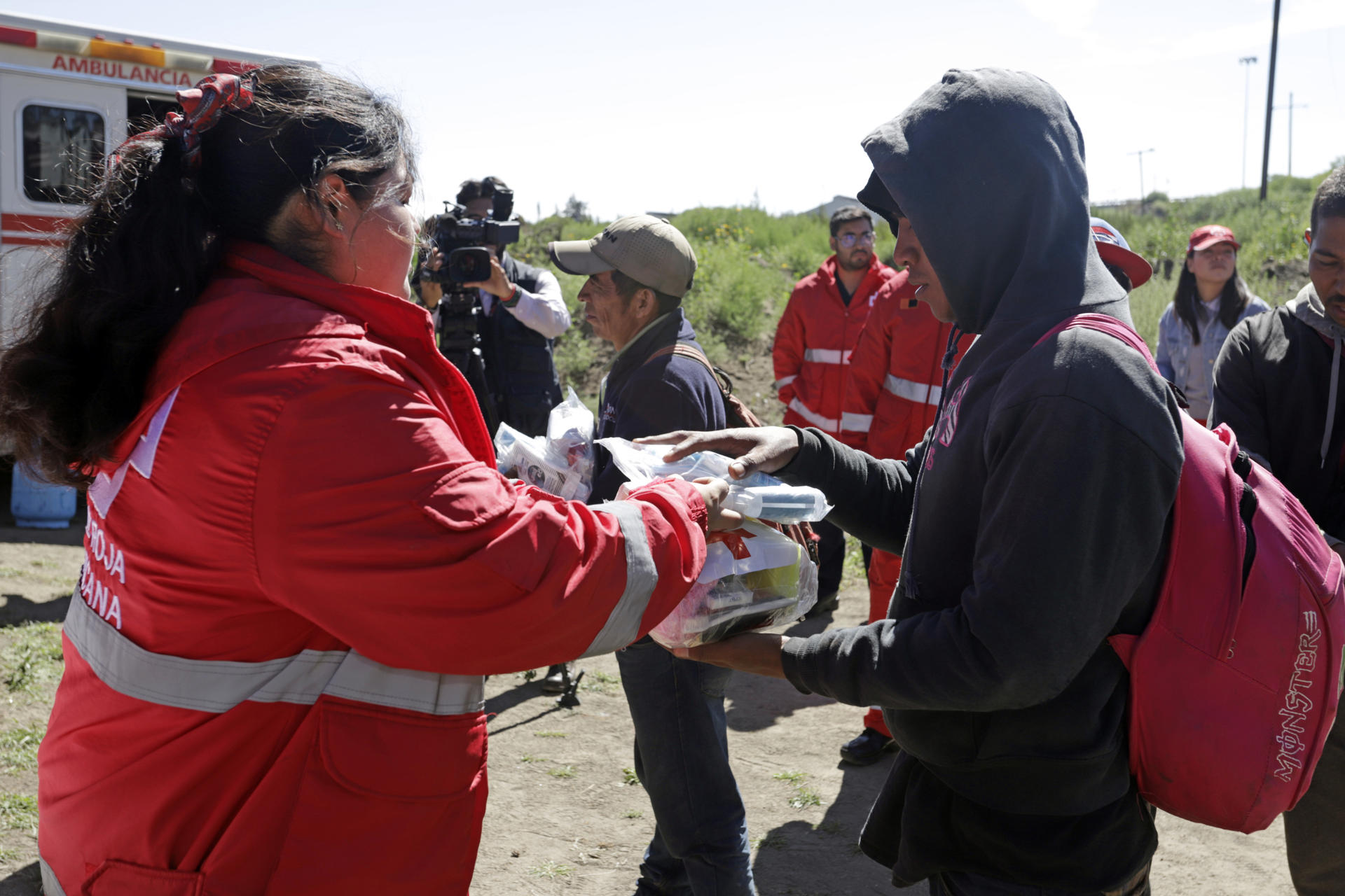 Una paramédica de la Cruz Roja, entrega alimentos a migrantes centroamericanos a un costado de la vía del tren denominado "La Bestia", hoy en la comunidad de Jesús Nazareno, perteneciente al municipio de Ciudad Serdán Estado de Puebla (México). EFE/ Hilda Ríos
