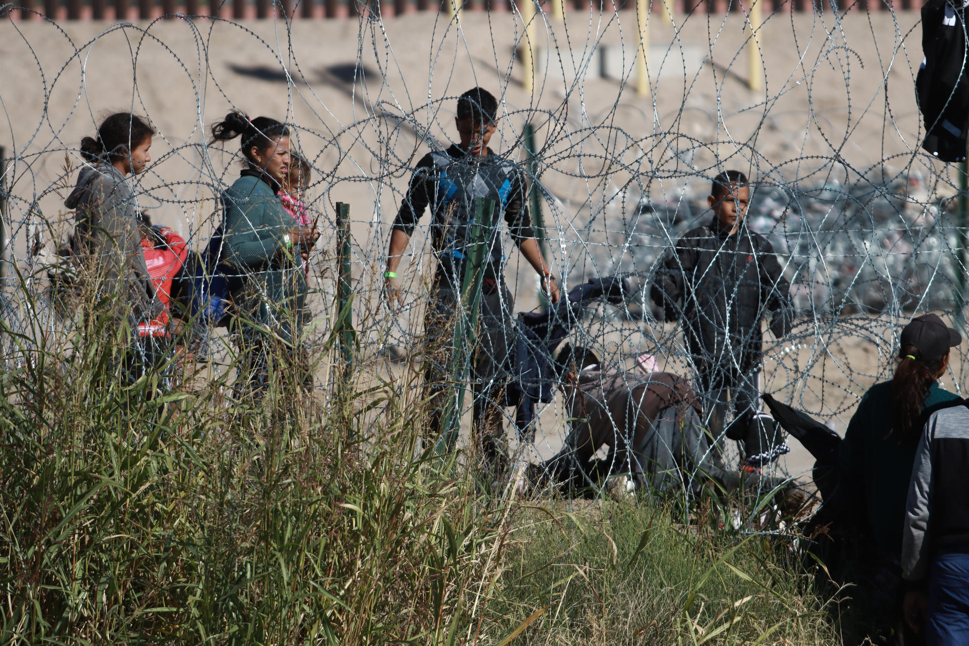 Migrantes permanecen cerca del muro que separa la frontera estadounidense, el 23 de noviembre de 2023, en la Ciudad Juárez, Chihuahua (México). EFE/ Luis Torres

