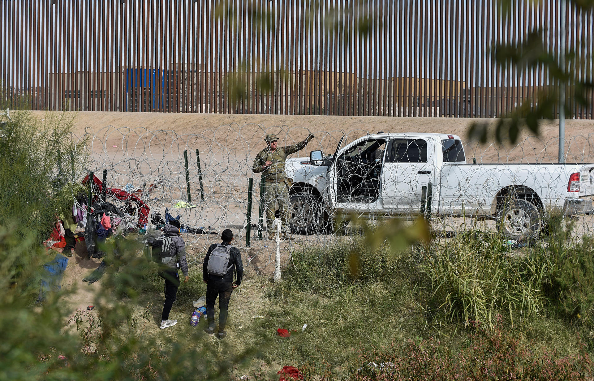 Migrantes hablan con un agente fronterizo de la frontera con Estados Unidos hoy, en Ciudad Juárez, en el estado de Chihuahua (México). EFE/Luis Torres
