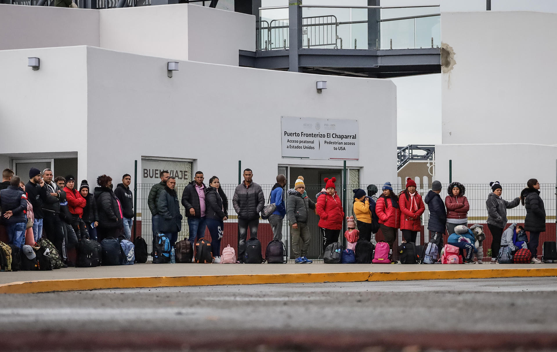 Migrantes hacen fila para solicitar un proceso de asilo en Estados Unidos, el 27 de diciembre de 2023 en el puerto fronterizo del Chaparral en Baja California (México). EFE/Joebeth Terríquez
