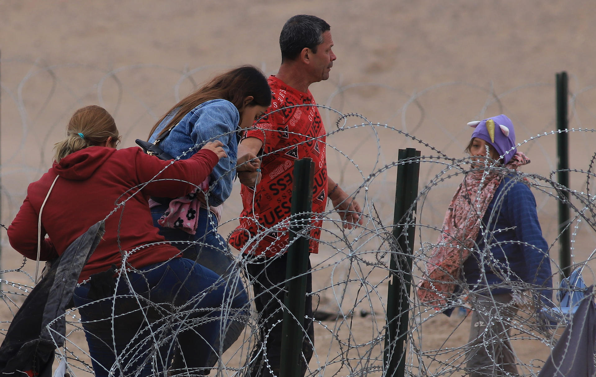 Migrantes cruzan una alambrada de navajas y púas, en el área fronteriza con Estados Unidos, el 29 de febrero de 2024, en Ciudad Juárez (México). EFE/ Luis Torres

