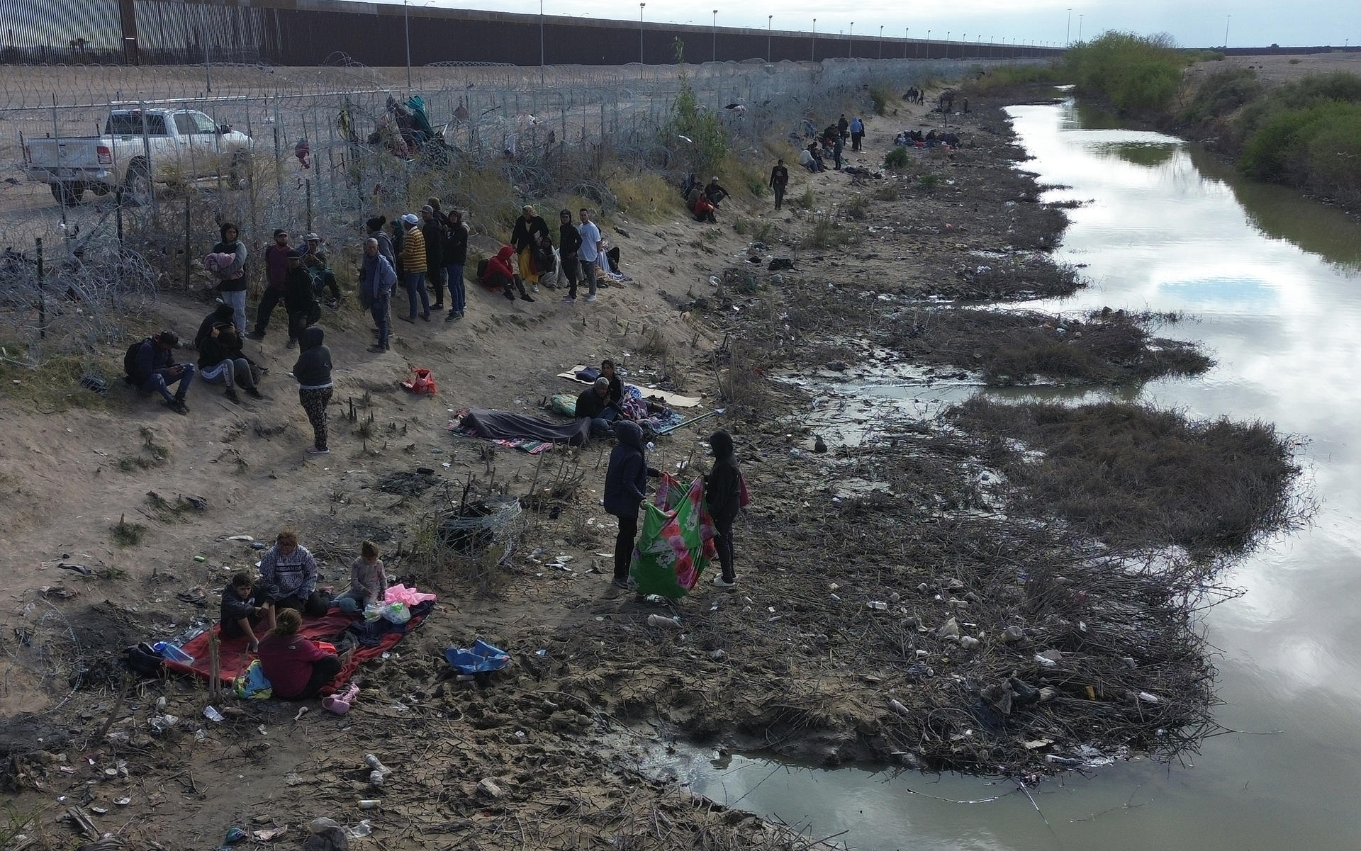 Migrantes permanecen en las inmediaciones del Río Bravo, junto al alambrado que divide a México con Estados Unidos, este miércoles, en Ciudad Juárez (México). EFE/ Luis Torres
