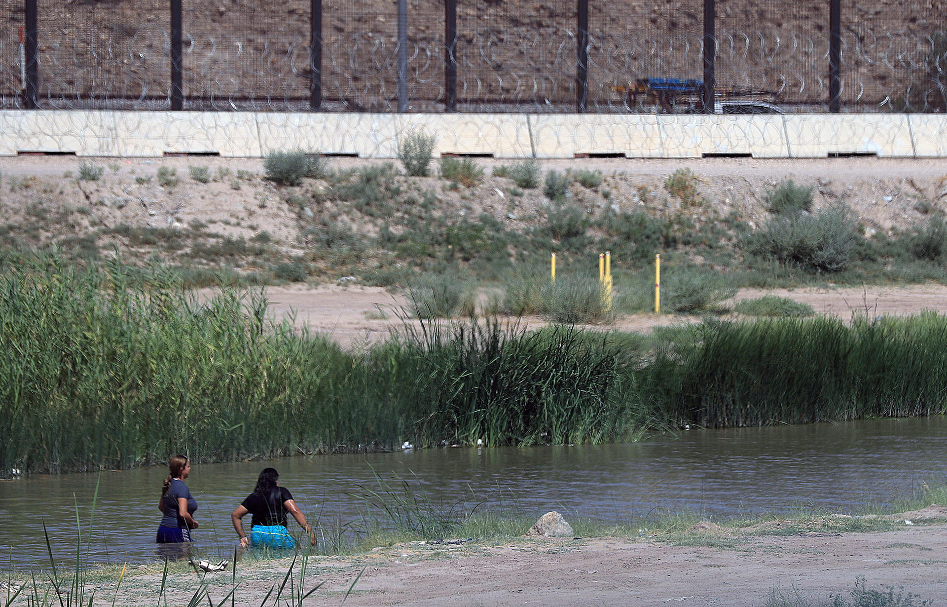 Dos mujeres migrantes cruzan el río Bravo, este miércoles en Ciudad Juárez (México). EFE/Luis Torres
