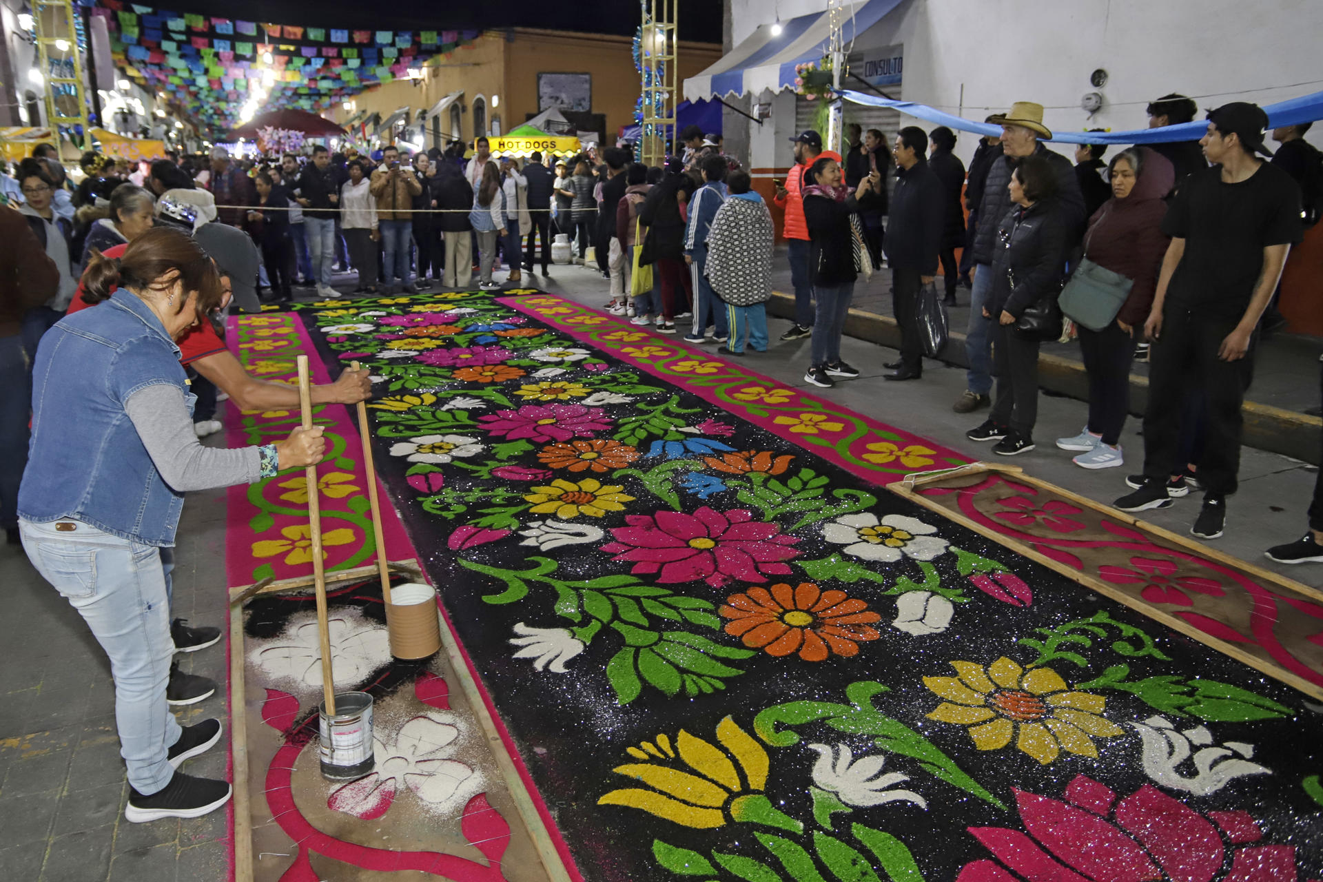 Fotografía del 14 de agosto de 2024 de artesanos elaborando tapetes de aserrín con distintos mosaicos y diseños para celebrar la ´Noche que Nadie Duerme', en el municipio de Huamantla, estado de Tlaxcala (México). EFE/Hilda Ríos
