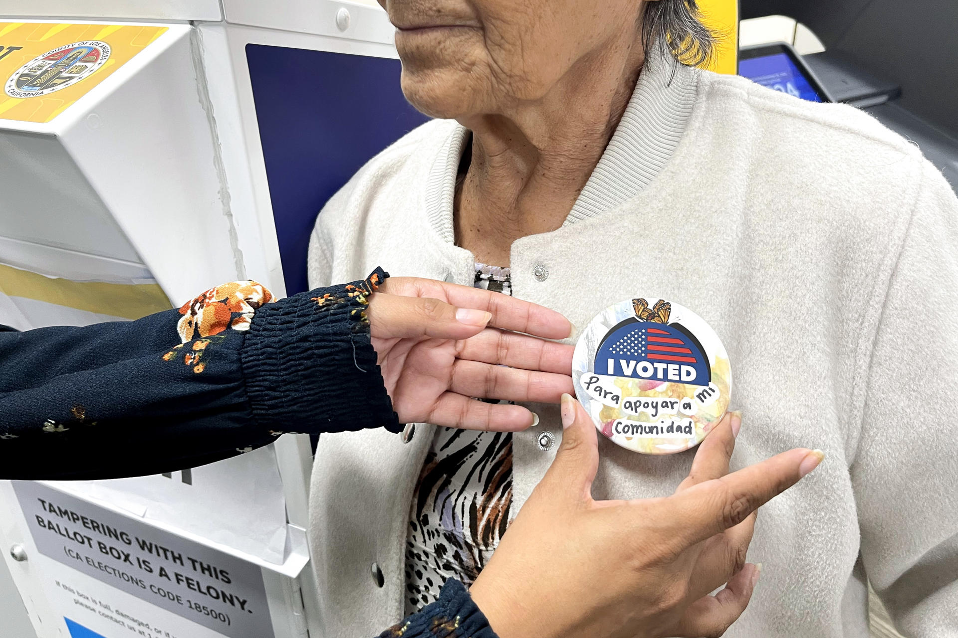 Fotografía del 2 de octubre de 2024 de una mujer recibiendo un botón después de votar en Los Ángeles, California (Estados Unidos). EFE/ Ana Milena Varón
