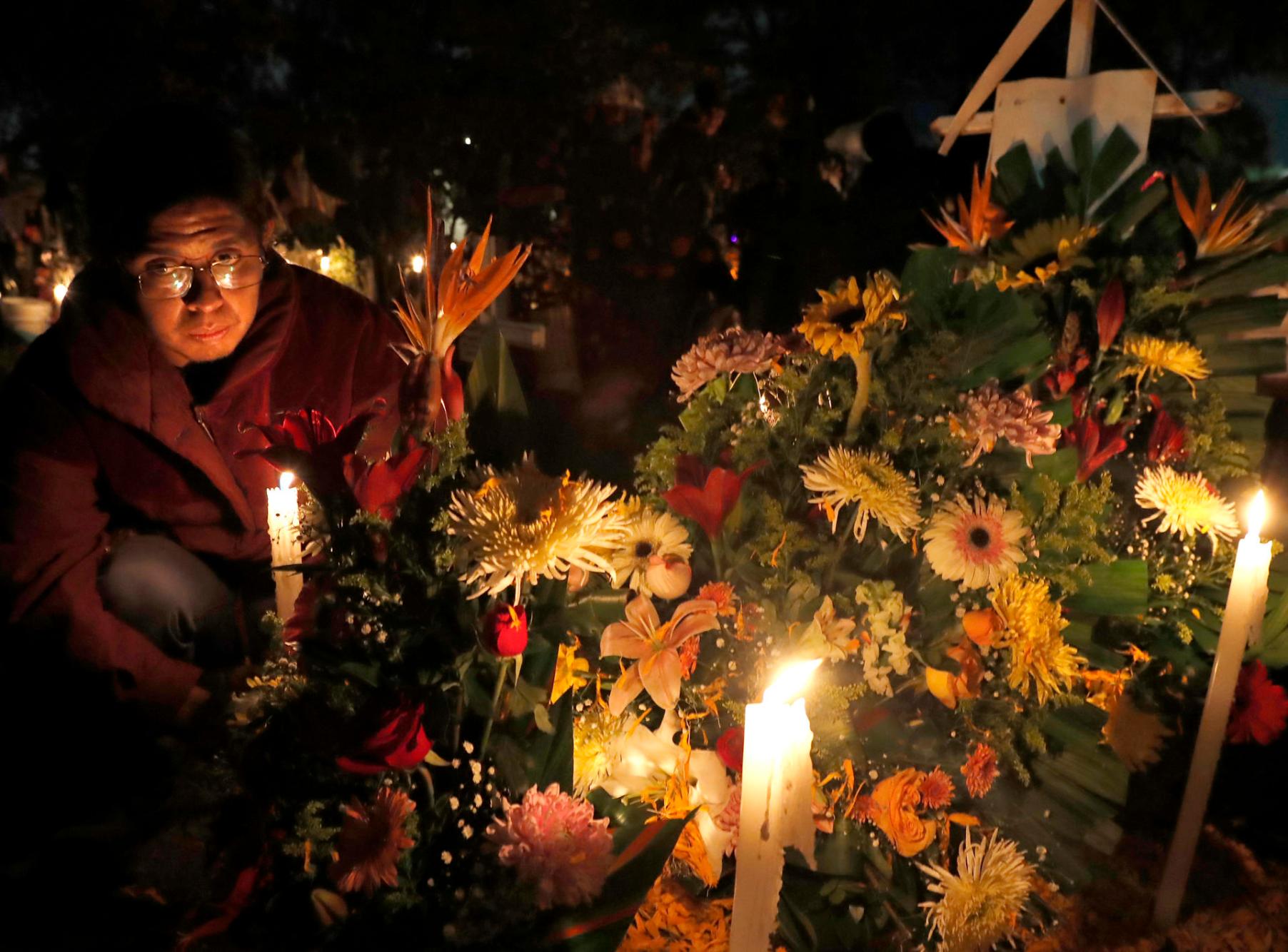 Familiares y amigos visitan a sus fieles difuntos la madrugada de este viernes en el panteón comunal San Gregorio Atlapulco, en la Ciudad de México (México). EFE/Mario Guzmán
