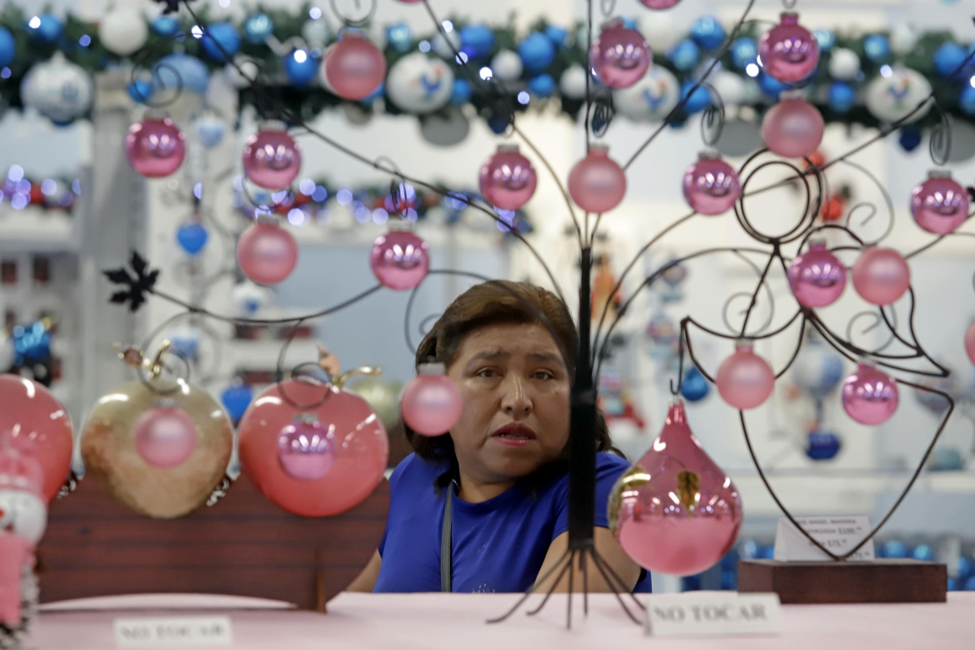 Una mujer observa esferas de vidrio soplado hechas por artesanos mexicanos este martes, en el municipio de Chignahupan, en el estado de Puebla (México). EFE/ Hilda Ríos
