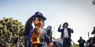 Activistas promigrantes queman figura de policía en protesta por abusos en Tijuana, México