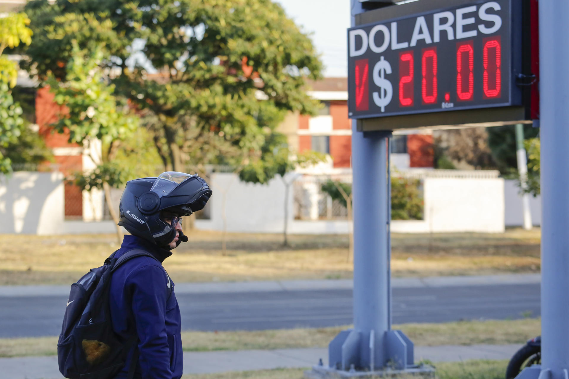 Una persona pasa frente a una casa de cambio este lunes, en la ciudad de Guadalajara, en Jalisco (México). EFE/ Francisco Guasco
