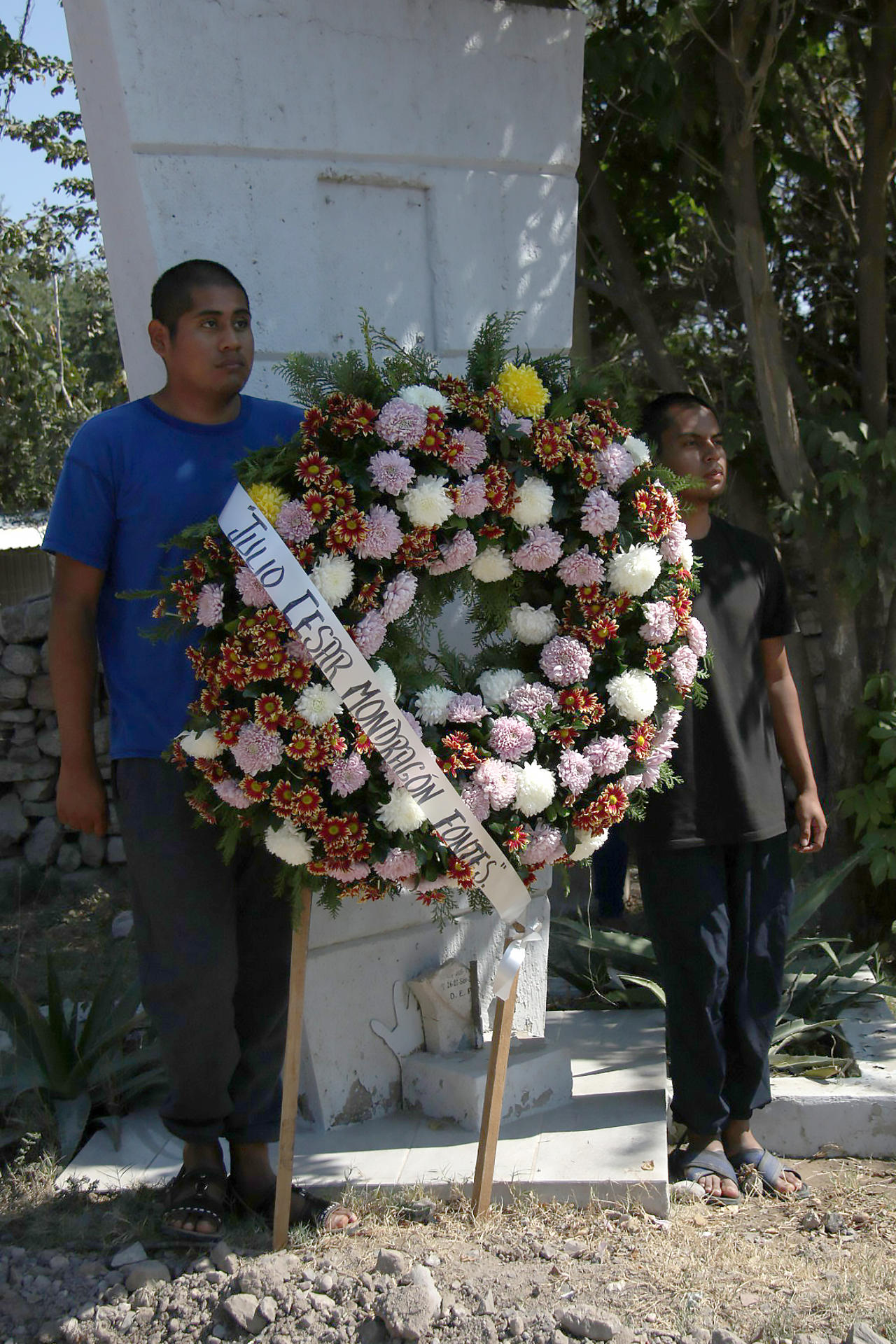 Compañeros de los 43 estudiantes desaparecidos de Ayotzinapa colocan un arreglo floral durante una manifestación este sábado, en Chilpancingo (México). EFE/ José Luis De La Cruz
